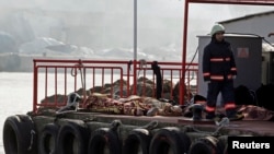 A rescue worker walks past bodies retrieved from the sea after a boat sank in the Bosphorus strait, near Istanbul, November 3, 2014. 