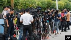 FILE - Journalists gather outside a hospital morgue in Seremban, Negeri Sembilan, Malaysia, Aug. 14, 2019.