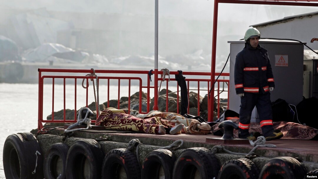A rescue worker walks past bodies retrieved from the sea after a boat sank in the Bosphorus strait, near Istanbul, November 3, 2014. 