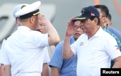 로드리고 두테르테(오른쪽) 필리핀 대통령이 지난 5월 남부 다바오시 인근을 친선방문한 중국 해군 함정 사령관의 경례를 받고있다.