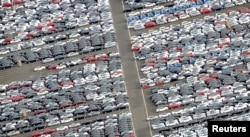 FILE - Cars for export stand in a parking area at a shipping terminal in the harbor of the northern German town of Bremerhaven, Oct. 8, 2012.