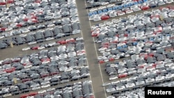 FILE - Cars for export stand in a parking area at a shipping terminal in the harbor of the northern German town of Bremerhaven, October 8, 2012. 
