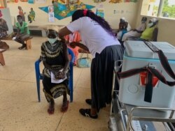 Mary Nyoka, 65, of South Sudan gets the AstraZeneca COVID-19 vaccine at Swinga Health Centre 3 in Bidibidi. settlement, Yumbe district, northern Uganda. (Halima Athumani/VOA)