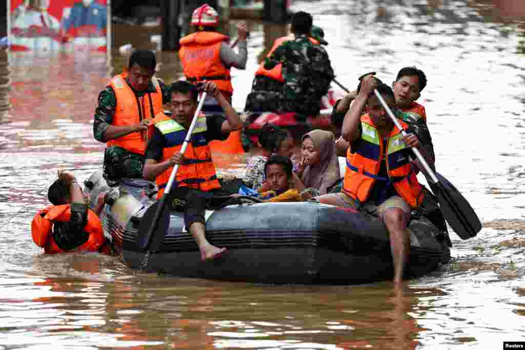 Rescuers evacuate people using a rubber boat from a flooded residential area following heavy rains in Jakarta, Indonesia.&nbsp;