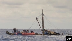 Anggota pasukan penjaga pantai Filipina (kiri) mendekati kapal nelayan yang hampir tenggelam, di perairan dekat kota Zamboanga, selatan Filipina, 10 Januari 2016. (Philippine Coast Guard via AP) 