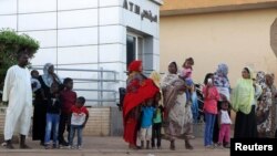 FILE - Residents stand outside an automated teller machine (ATM) in Khartoum, Sudan, Nov. 8, 2018.