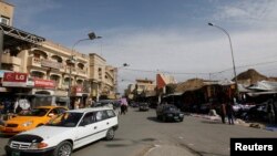 FILE - Vehicles drive past in a street in Mosul, 390 km (240 miles) north of Baghdad, March 12, 2012. Islamic State militants occupied the city in mid-2014.