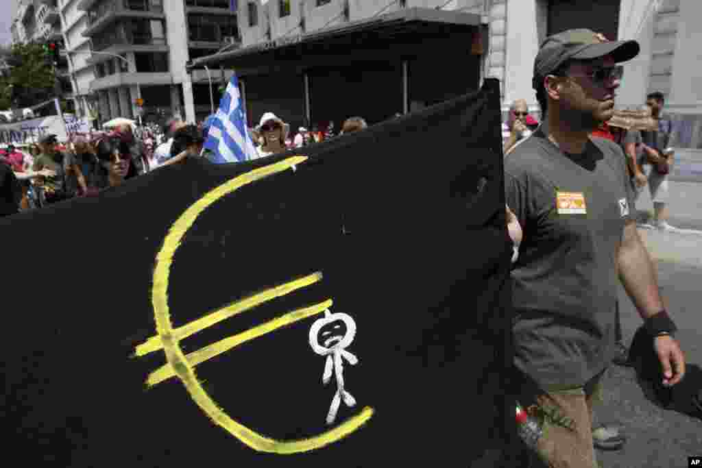 A protester holds a banner featuring a man hanging from a Euro logo as he marches to the Greek Parliament during a protest in Athens, July 16, 2013.&nbsp;