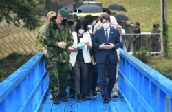 Menteri Unifikasi Korea Selatan Lee In-young (kanan), berjalan di jembatan biru saat berkunjung ke Panmunjom di Zona Demiliterisasi, Korea Selatan, Rabu, 16 September 2020.