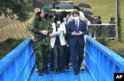 Menteri Unifikasi Korea Selatan Lee In-young (kanan), berjalan di jembatan biru saat berkunjung ke Panmunjom di Zona Demiliterisasi, Korea Selatan, Rabu, 16 September 2020.
