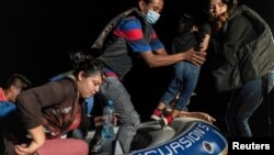 Familias migrantes solicitantes de asilo desembarcan en una balsa inflable después de cruzar el río Grande hacia los Estados Unidos desde México en Roma, Texas, el 9 de junio de 2021.