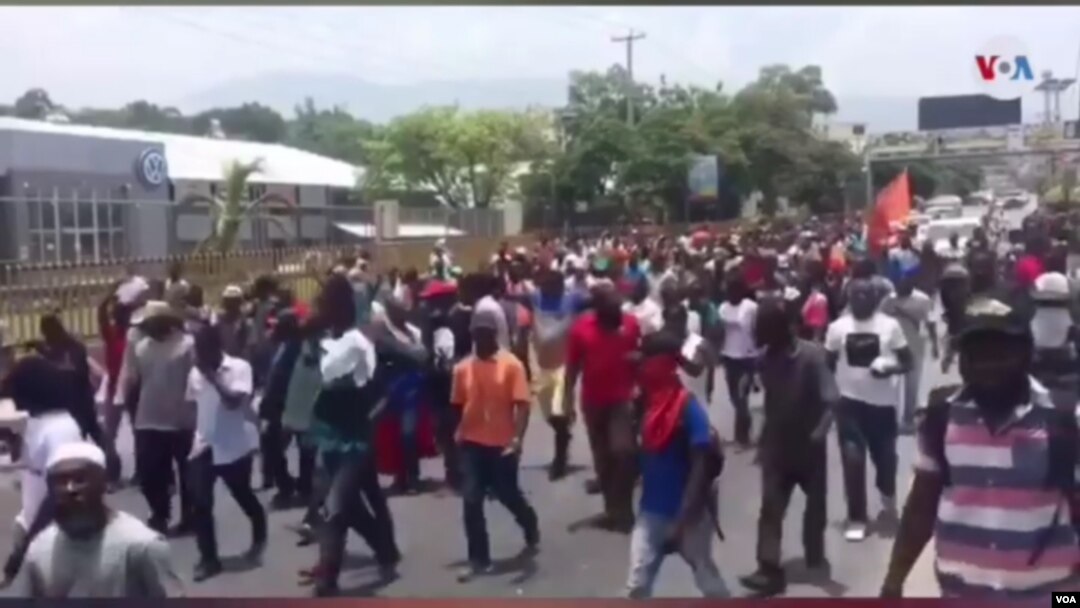Para pengunjuk rasa berpawai melewati Kedutaan Besar AS di Port au Prince, Haiti, 29 Juli 2019. (VOA/S. Lemaire)