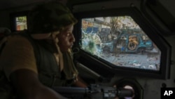 FILE - A Kenyan police officer, part of a UN-backed multinational force, patrols a street in Port-au-Prince, Haiti, Dec. 5, 2024.