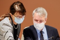 Finland's Foreign Minister Pekka Haavisto and Special Representative of the Secretary General of the U.N. for Afghanistan, Deborah Lyons wear masks prior to the plenary session of the 2020 Afghanistan Conference in Geneva, Nov. 24, 2020.