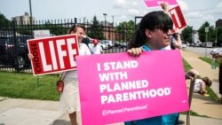 FILE - Abortion rights and anti-abortion rights protesters stand outside Planned Parenthood as a deadline looms to renew the license of Missouri's sole remaining Planned Parenthood clinic in St. Louis, May 31, 2019.
