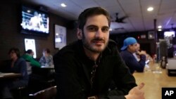 Matt Garlock, of Mansfield, Mass., poses for a photo in a bar in Somerville, Mass. The 29-year old has trouble making out what his friends say in loud bars, but when he got a hearing test, the result was normal, Feb. 22, 2017.