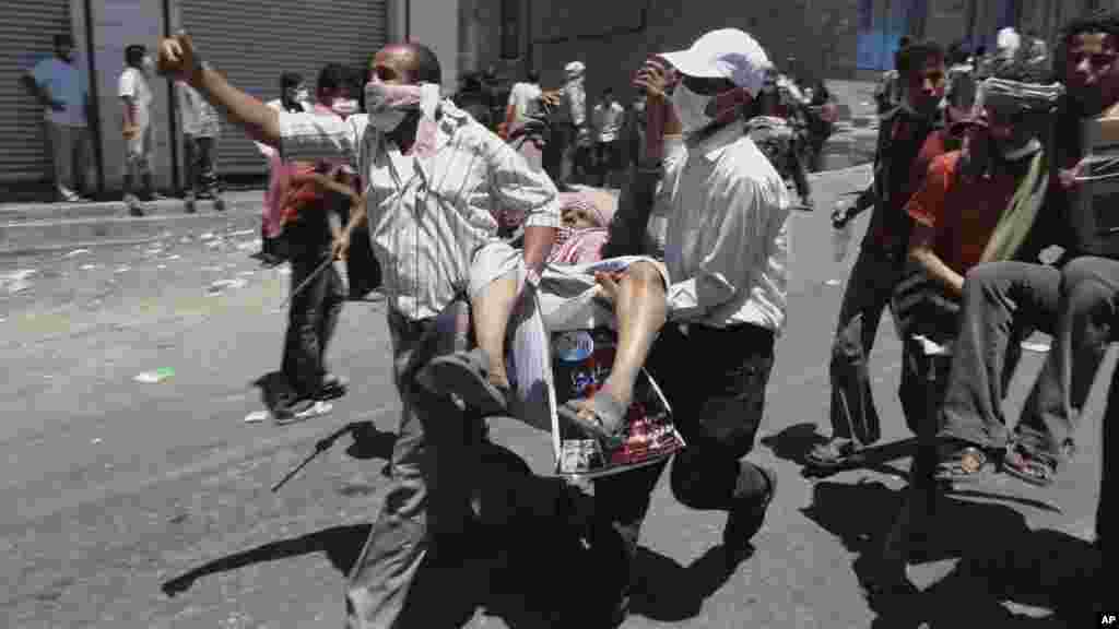 Manifestantes anti-governamentais transportam ferido depis de confrontos com forças iemenitas em Taiz, 5 de Abril 2011.