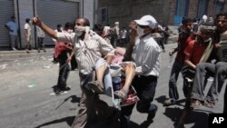 Des manifestants antigouvernementaux transportent un homme blessé lors d'affrontements avec les forces yéménites à Taiz, au Yémen, le 5 avril 2011. (AP Photo / Yemen Lens, File)