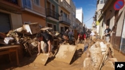 Los residentes y voluntarios intentan retirar el barro en una zona afectada por las inundaciones en Paiporta, cerca de Valencia, España, el 1 de noviembre de 2024.