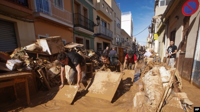 Los residentes y voluntarios intentan retirar el barro en una zona afectada por las inundaciones en Paiporta, cerca de Valencia, España, el 1 de noviembre de 2024.