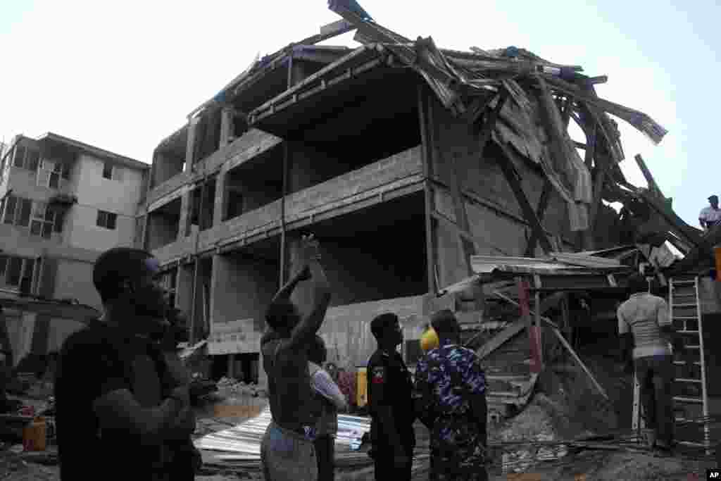 Police officers, rescue workers and onlookers gather near the site of a building under construction which collapsed in Lagos, Nigeria, Nov, 4. 2013. 