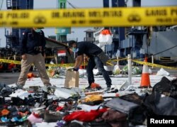 Para petugas forensik mengumpulkan sampel barang-barang dari pesawat Lion Air penerbangan JT610 yang jatuh di Laut Jawa. Barang-barang tersebut dikumpulkan di Tanjung Priok, Jakarta, 2 November 2018. (Foto:Reuters)