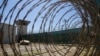 FILE - In this April 17, 2019, photo, reviewed by U.S. military officials, the control tower is seen through the razor wire inside the Camp VI detention facility in Guantanamo Bay Naval Base, Cuba. 