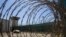 FILE - In this April 17, 2019, photo, reviewed by U.S. military officials, the control tower is seen through the razor wire inside the Camp VI detention facility in Guantanamo Bay Naval Base, Cuba. 