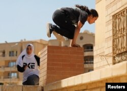 Para perempuan Mesir dari Parkour Egypt “PKE” melatih keterampilan parkour di gedung-gedung sekitar di Kairo, Mesir, 20 Juli 2018.