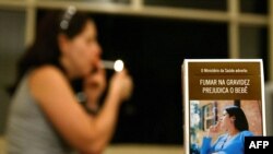 ARCHIVO - Una caja de cigarrillos de Brasil muestra la fotografía de una mujer embarazada fumando con la leyenda "El Ministerio de salud advierte que fumar es perjudicial para la salud del niño". 