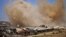 FILE - Smoke rises above opposition-held areas of the Daraa province countryside during airstrikes by Syrian regime forces, June 27, 2018.
