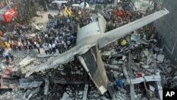 Rescuers search for victims at the site where an air force cargo plane crashed in Medan, North Sumatra, Indonesia, Tuesday, June 30, 2015. 