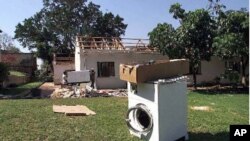 Farm workers clean up at Les de Jager's "Two Trees" farm in the Lions Den area, 150 kilometers north of Harare, Zimbabwe after looters ransacked the house, stripping the home and causing damage to farm equipment. The looters abandoned the washing machine 