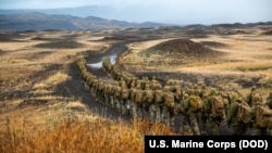 U.S. Marines with the 24th Marine Expeditionary Unit hike to a cold-weather training site inland, Iceland, Oct. 19, 2018, during Exercise Trident Juncture 18. 