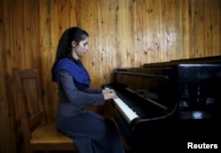 Negin Khpolwak, leader of the Zohra orchestra, an ensemble of 35 women, practices on a piano at Afghanistan's National Institute of Music, in Kabul, Afghanistan, April 9, 2016.