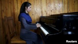 Negin Ekhpulwak, pemimpin Orkestra Zohra yang beranggotakan 35 orang, berlatih piano di Institut Musik Nasional Afghanistan di Kabul (9/4). (Reuters/Ahmad Masood)