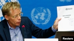 World Health Organization Assistant Director General Bruce Aylward holds up a document titled "Ebola response roadmap" during a press briefing at the United Nations headquarters in Geneva, Aug. 28, 2014.