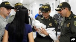 In this June 1, 2018 photo provided by the Colombia National Police, officers arrive to a hospital with an abandoned newborn baby girl who was discovered swaddled by a car near a stadium in Cucuta, Colombia.