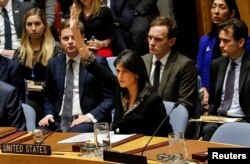 FILE - U.S. Ambassador to the United Nations Nikki Haley vetoes an Egyptian-drafted resolution regarding recent decisions concerning the status of Jerusalem, during a Security Council meeting on the situation in the Middle East, Dec. 18, 2017.