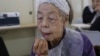 Yoshiko Abe applies lipstick at a makeup class at a community center room in Tokyo, Feb. 14, 2025.