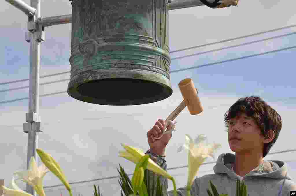 Ian-Benjamin Sasaki Herman, 13, ringing a memorial bell for the quake and tsunami victims in Ishinkomaki, March 9, 2012. (VOA - S. L. Herman) 