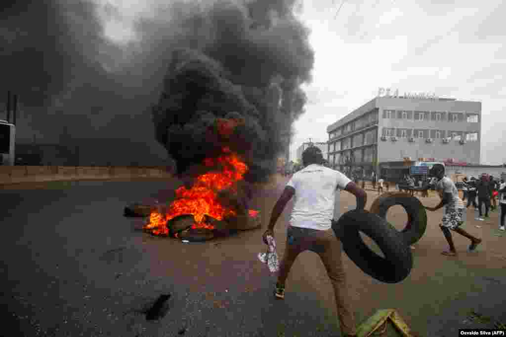 Manifestantes fazem uma barricada queimando pneus durante uma manifesta&#231;&#227;o contra o governo em Luanda. A pol&#237;cia anti-motim, alguns montados em cavalos, disparou g&#225;s lacrimog&#233;neo e agrediu dezenas de manifestantes que tomaram as ruas da capital angolana. 