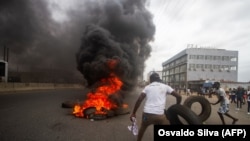Manifestantes fazem barricada queimando pneus durante uma manifestação contra o Governo em Luanda, 24 outubro 2020