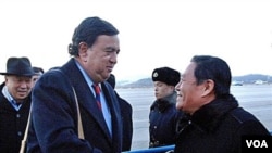 Pejabat Kementerian Luar Negeri Korut Li Gun menyambut Bill Richardson (kiri) di bandara Pyongyang, Korea Utara, Minggu, 19 Desember.