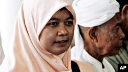 A Thai-Muslim woman activist holds a book with the cover showing a photo of missing Thai lawyer Somchai Neelapaichit (file photo)