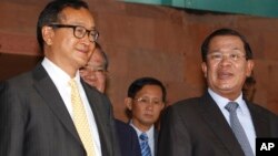 Cambodian Prime Minister Hun Sen, right, talks with the main Opposition Party leader Sam Rainsy, left, of Cambodia National Rescue Party, after their meeting in Senate headquarters in Phnom Penh, Cambodia, July 22, 2012. 