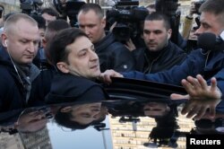 FILE - Ukrainian presidential candidate and comedian Volodymyr Zelenskiy gets into a car after undergoing a drugs and alcohol test, which is a precondition to participate in a policy debate ahead of the second round of a presidential election, outside a hospital in Kyiv, Ukraine, April 5, 2019.