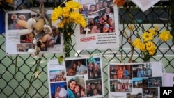 Foto-foto untuk mengenang korban kondominium Champlain Towers South yang ambruk di Miami, Florida, terpasang di sebuah pagar, 6 Juli 2021.