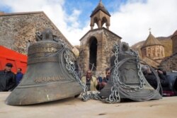People look at bells, removed from the Dadivank, an Armenian Apostolic Church monastery dating to the ninth century, as ethnic Armenians leave the separatist region of Nagorno-Karabakh for Armenia, Nov. 14, 2020.