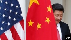 中国主席习近平从中国国旗后面走出来，参加白宫联合记者会（2015年9月25 日）